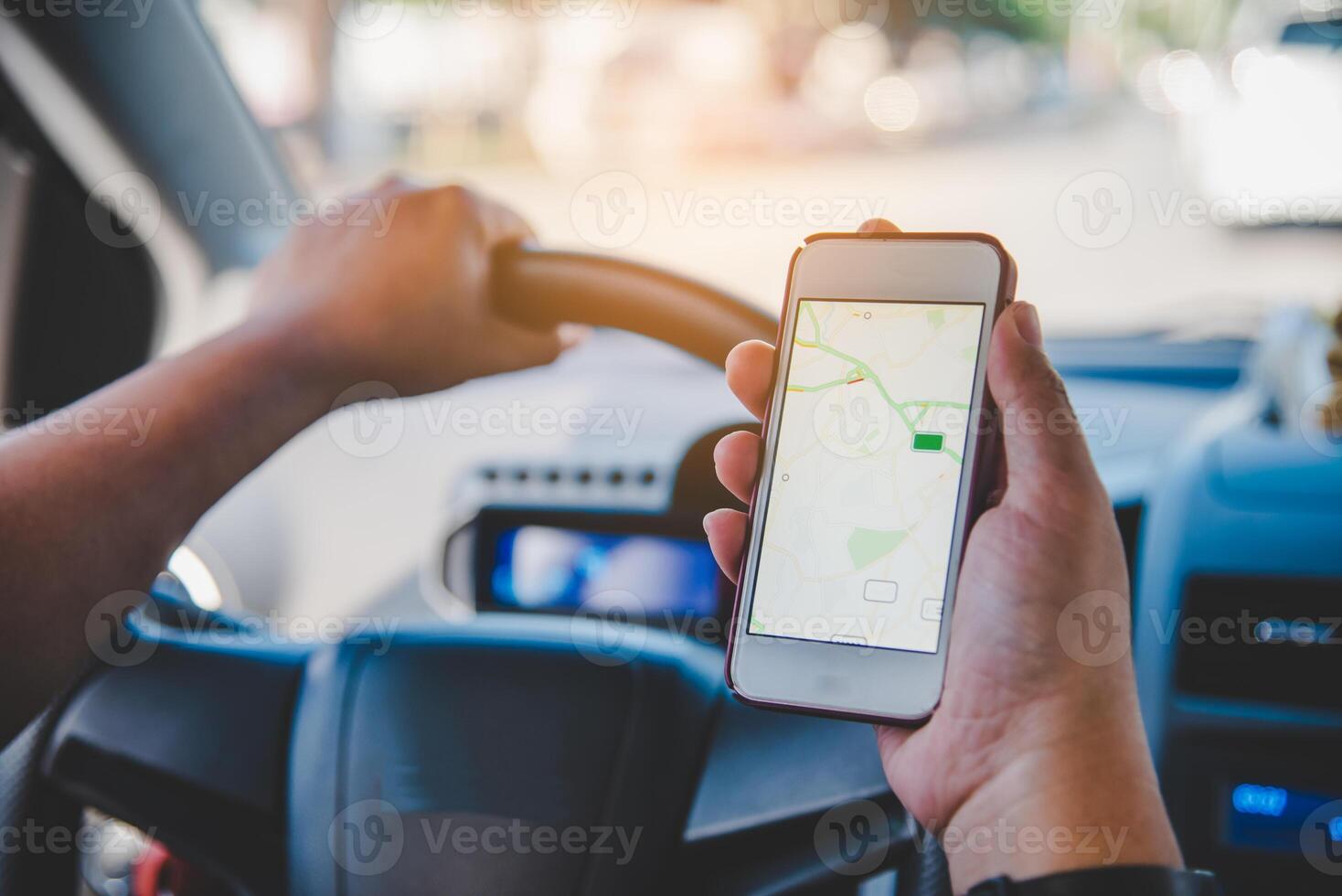 driver sitting in the car and holding  mobile smart phone with map gps navigation application photo