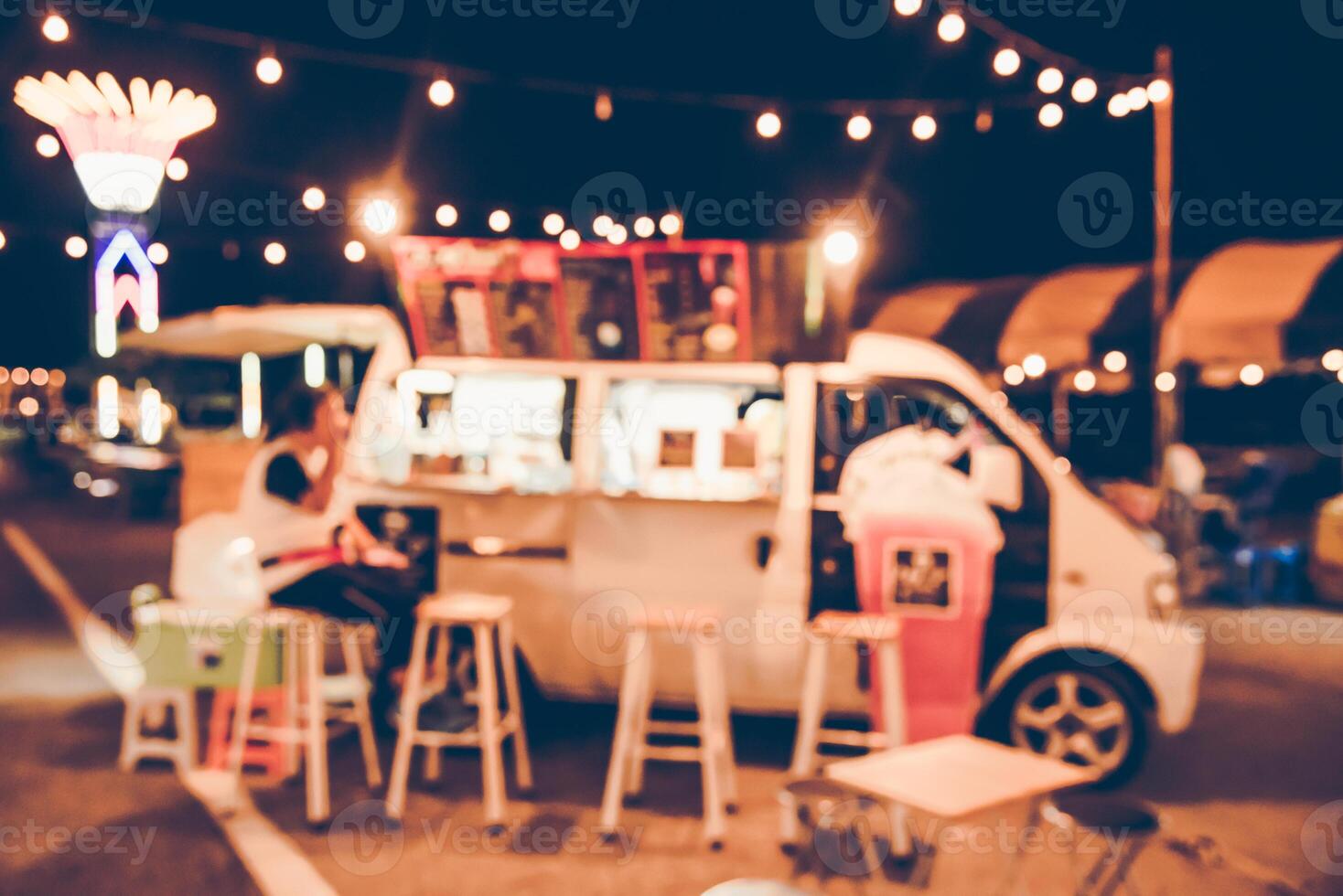 Blurred images of the background party in the festive festivities during the night, consisting of people and glittering bokeh. photo