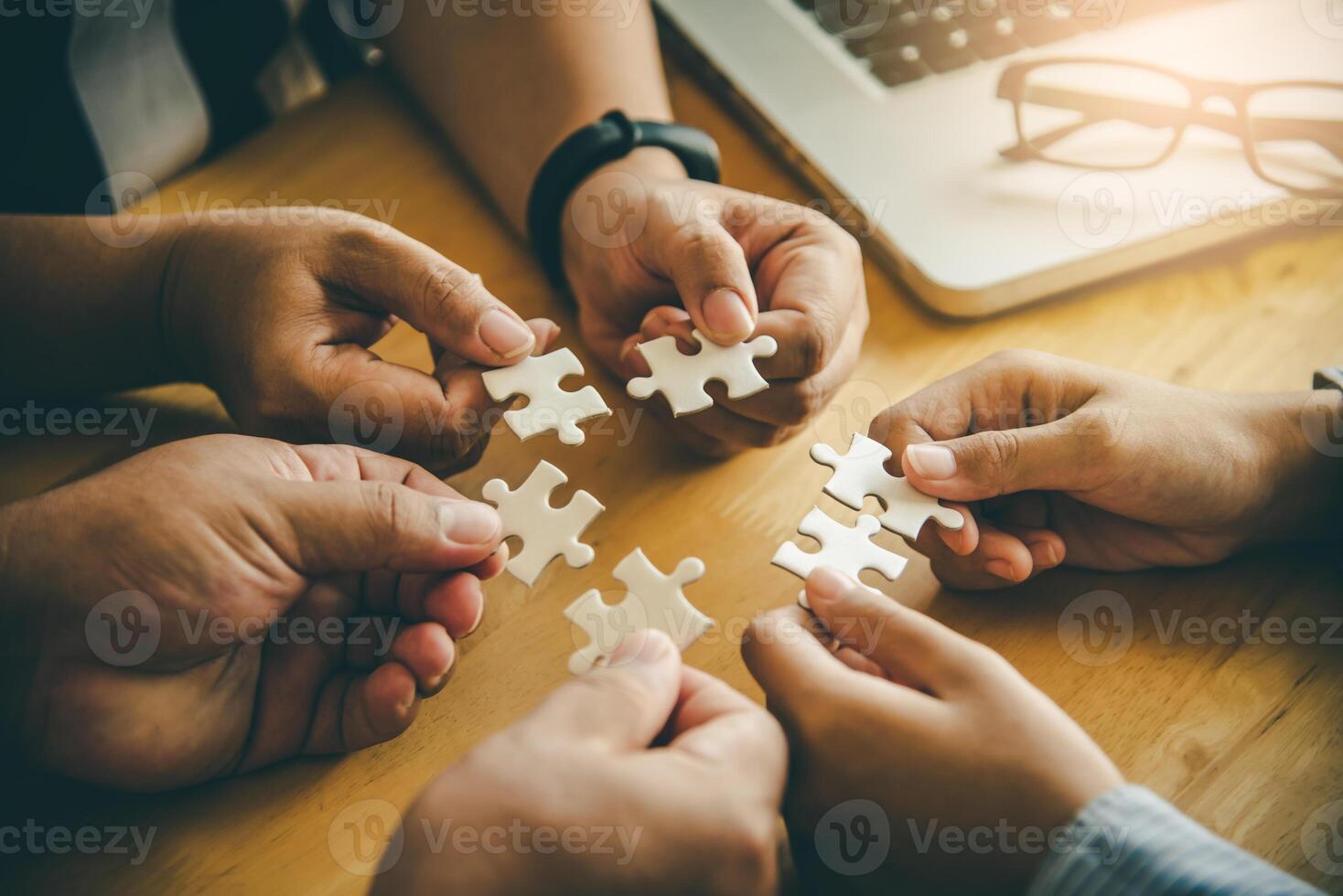 Business team handle a piece of white puzzles that are about to drop to get a complete worksheet - An attempt to succeed. photo