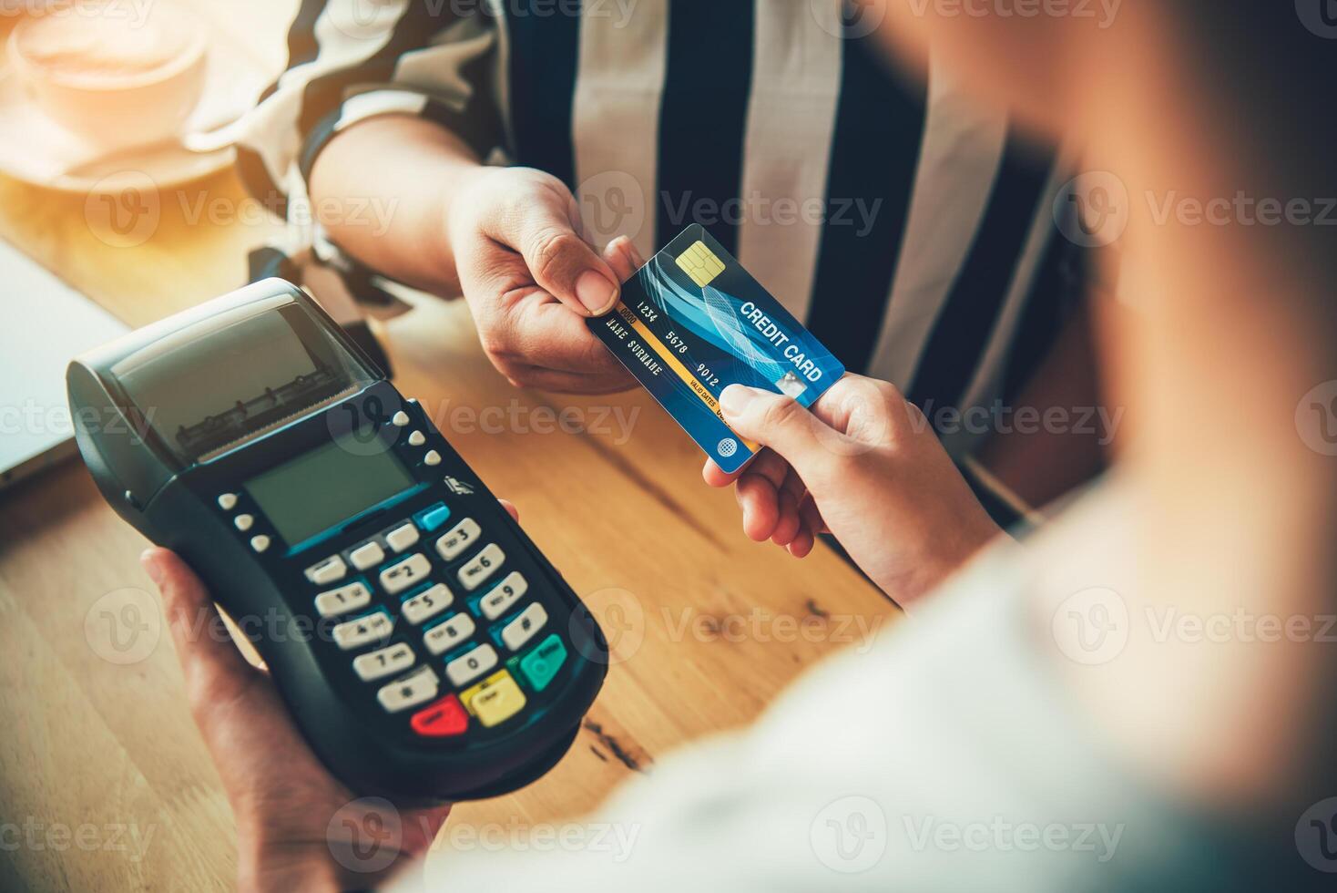 Close up of hand using credit card to pay by sending the credit card to the staff at the credit card swipe machine. Online payment photo