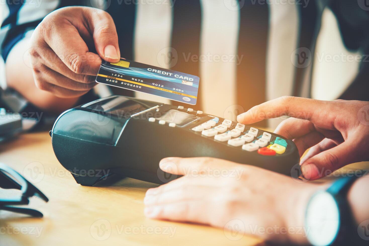 Close up of hand using credit card to pay by sending the credit card to the staff at the credit card swipe machine. Online payment photo