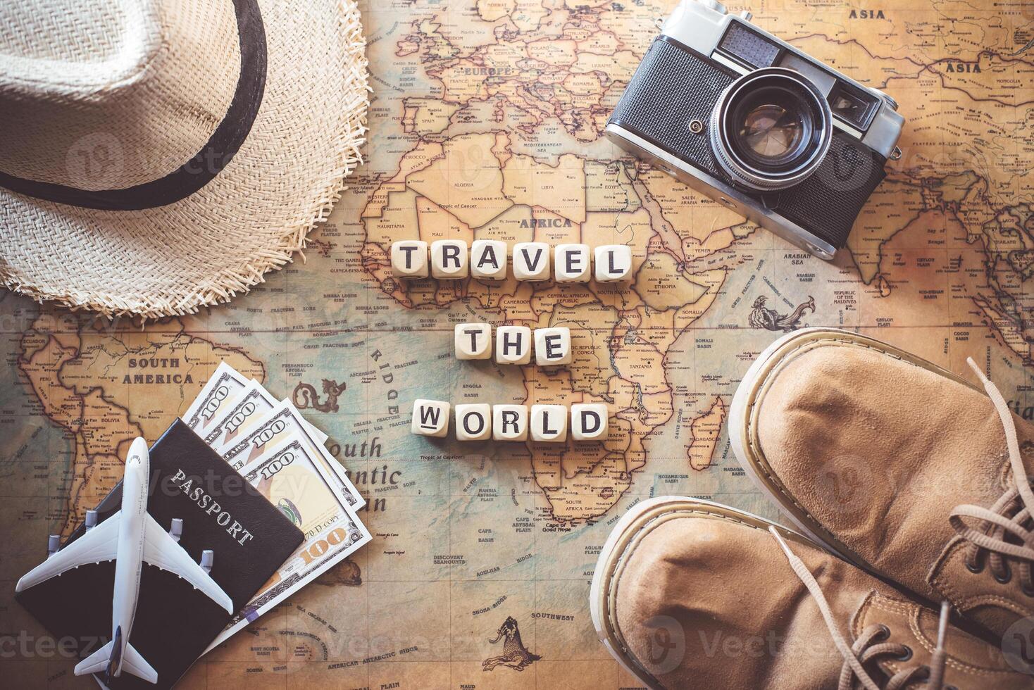 keywords  TRAVEL THE WORLD  and items accessories for the traveler are on the world map. Tourism concept photo