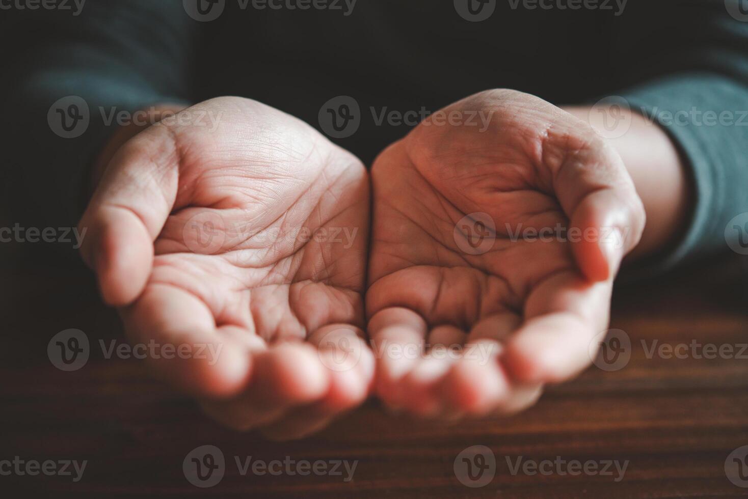 open two hands on wood background - concept help photo