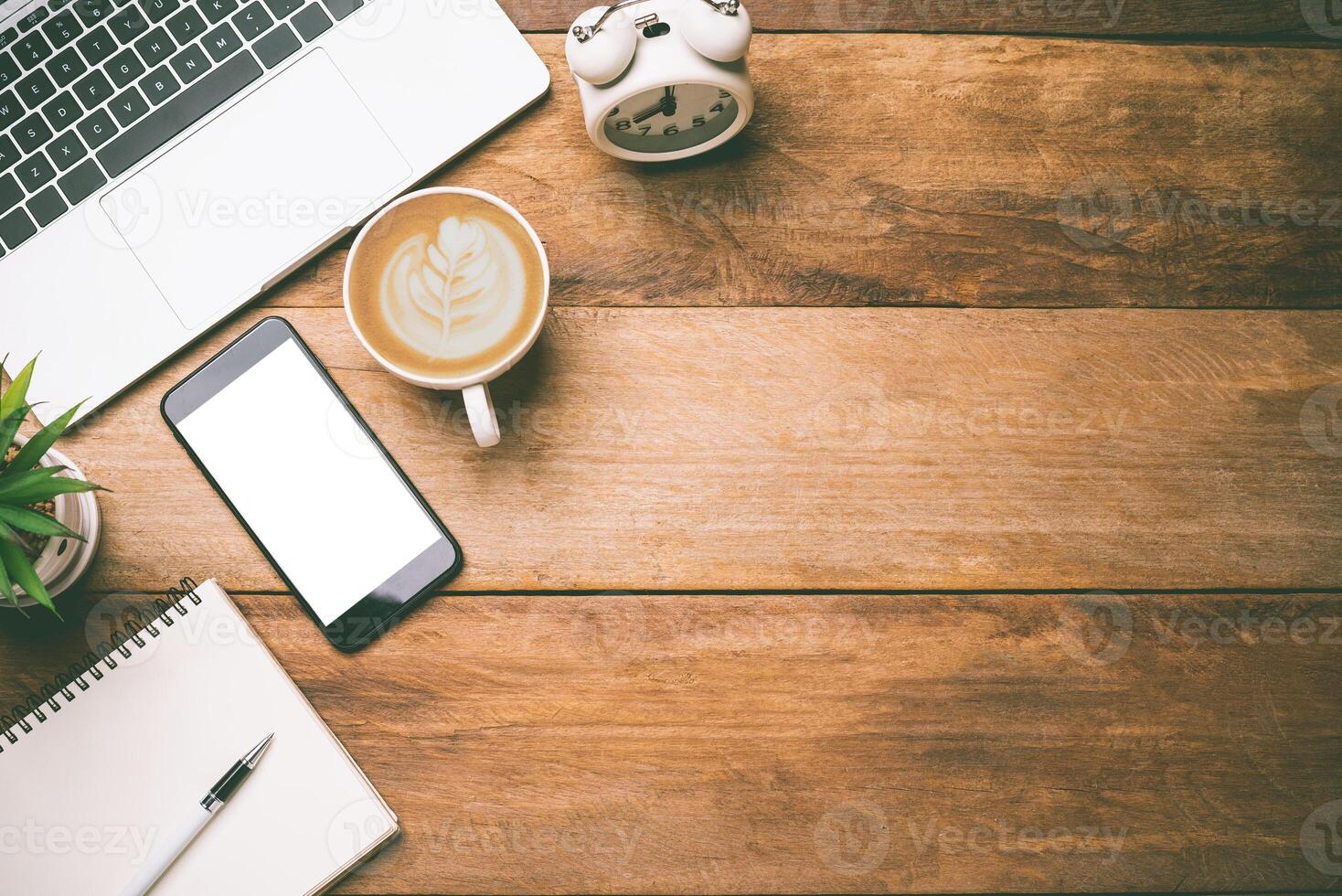 top view Office equipment including Laptop, mobile phone, mouse, notebook, coffee cup on the wood floor photo