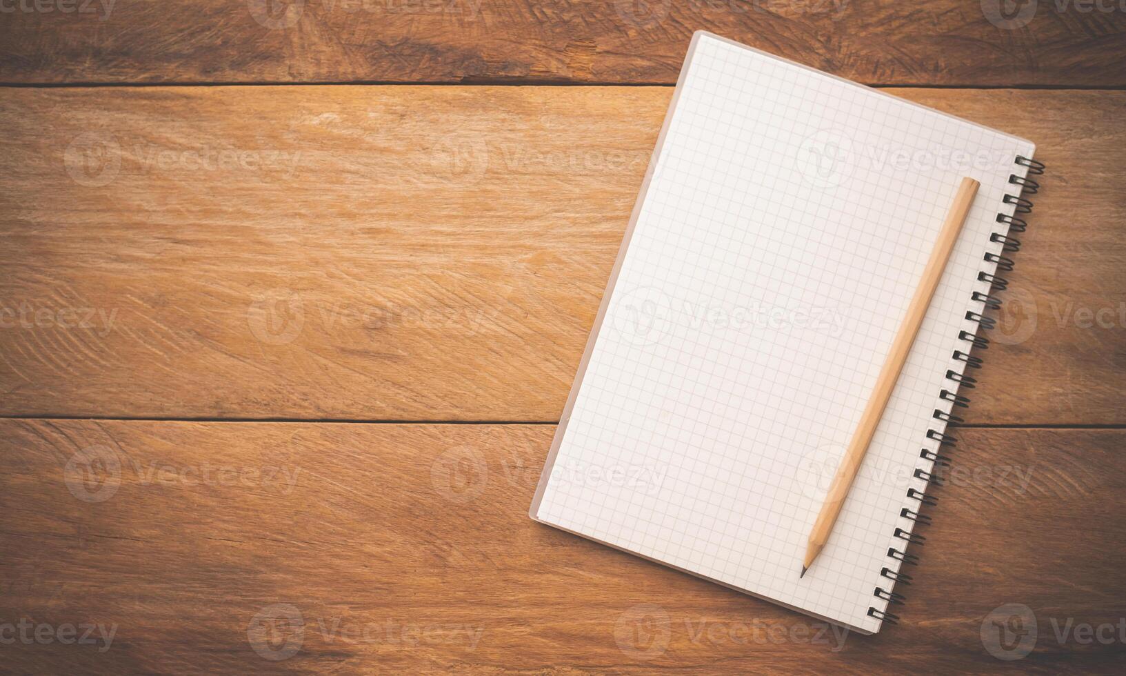 White notebooks and pencil laying on a wooden table photo