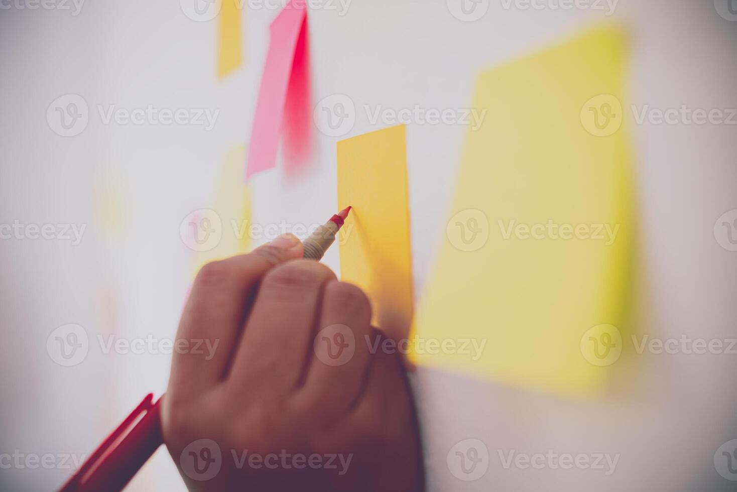 The hand is holding the post it notes attached to the wall. Concept brainstorming, share idea. photo
