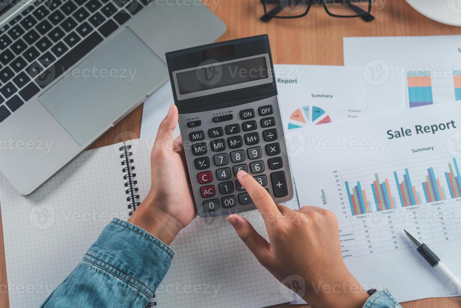 The accountant's hand is using the calculator. For cost analysis Profit and loss and tax calculation concept preparation of financial statements photo