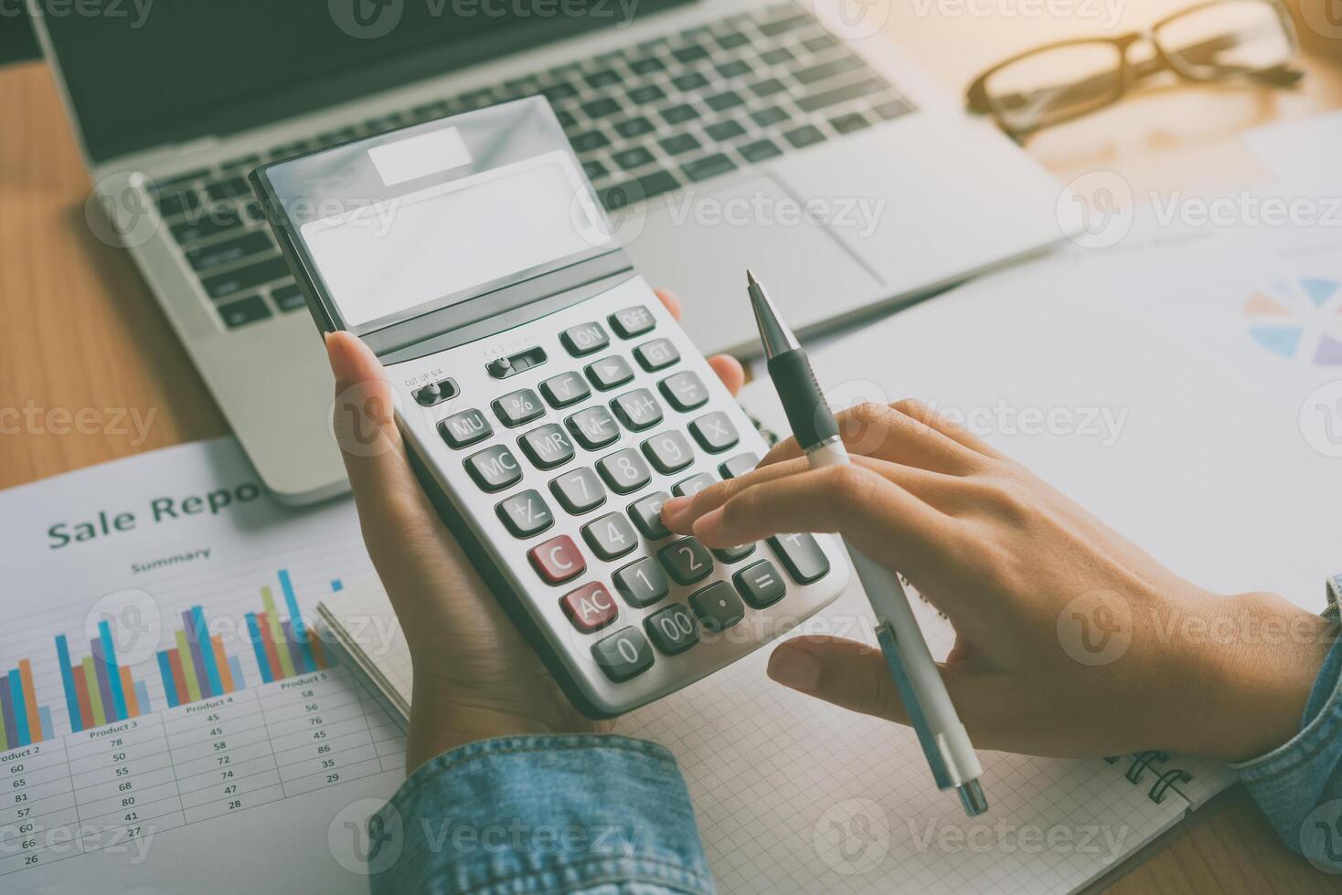 The accountant's hand is using the calculator. For cost analysis Profit and loss and tax calculation concept preparation of financial statements photo