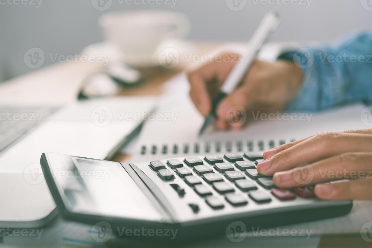 The accountant's hand is using the calculator. For cost analysis Profit and loss and tax calculation concept preparation of financial statements photo