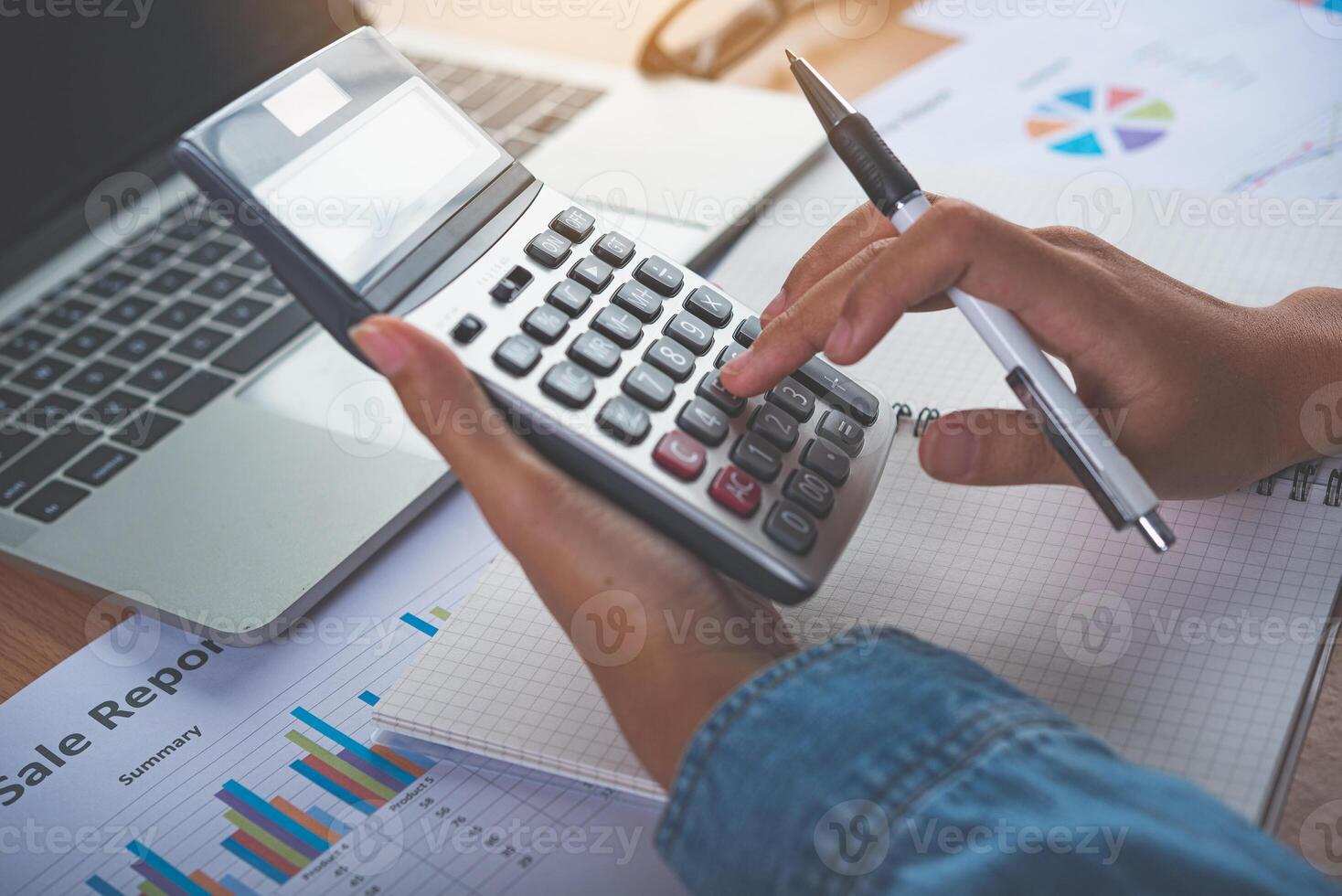 The accountant's hand is using the calculator. For cost analysis Profit and loss and tax calculation concept preparation of financial statements photo