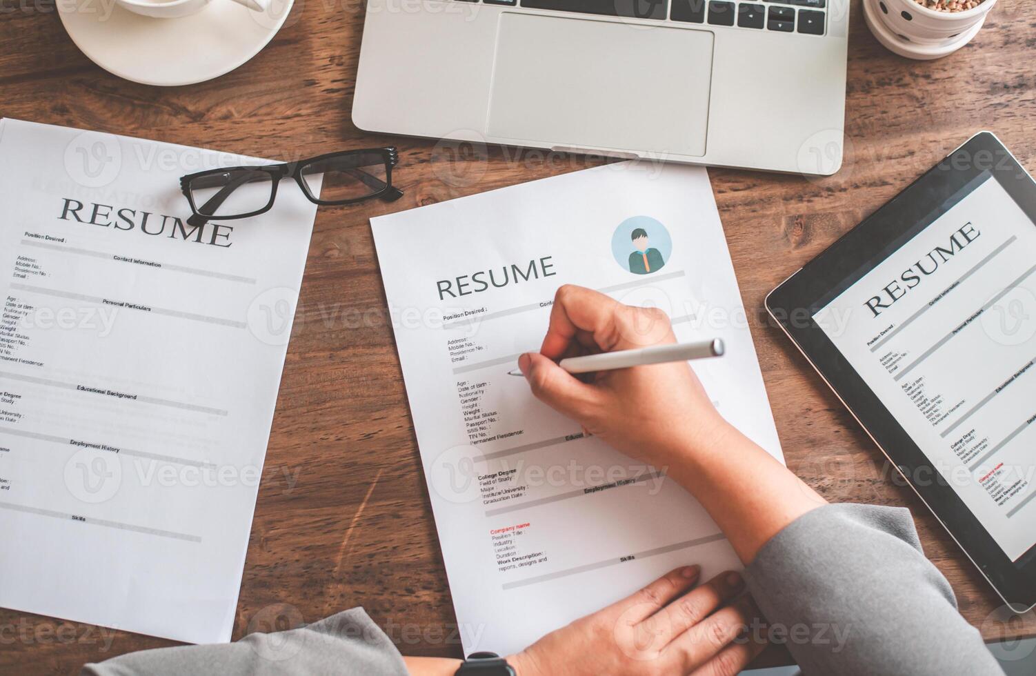 Top view people are filling out their resume on the job application form to apply for a job at a company. photo