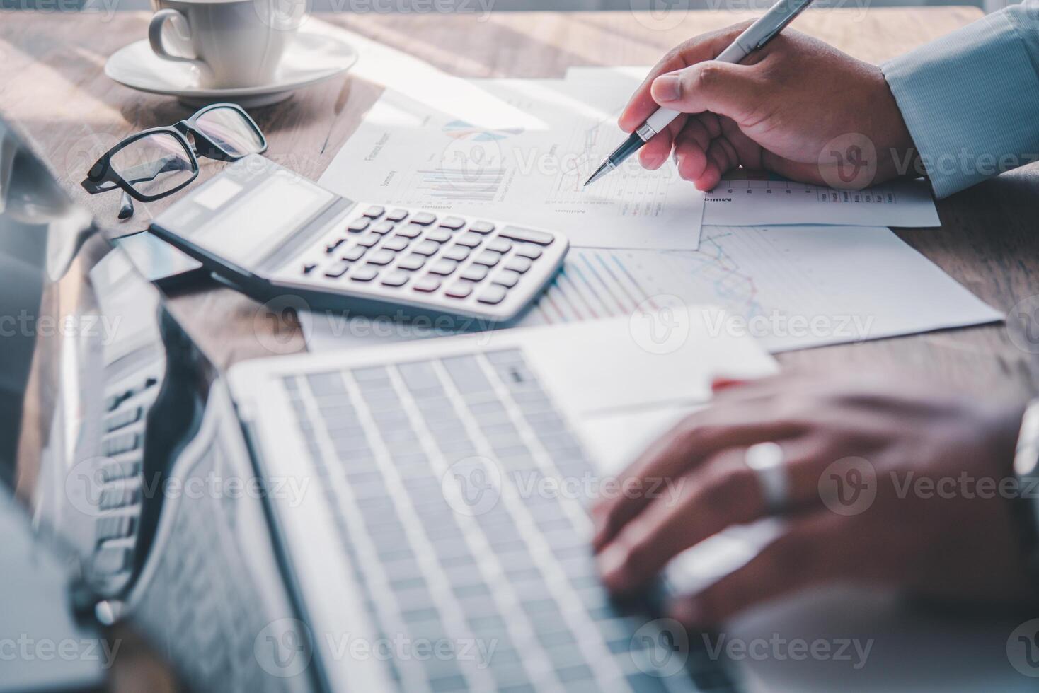 businessman pointing with pen on business report chart are working on accounts in business analysis with graphs and documentation. photo
