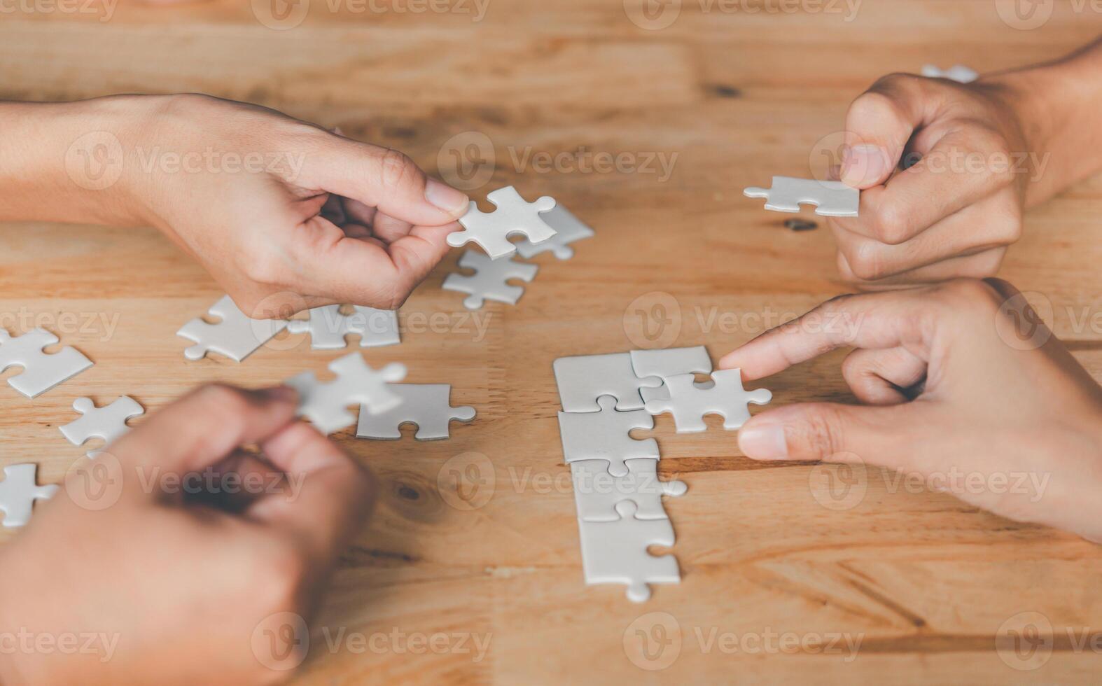 Business team handle a piece of white puzzles that are about to drop to get a complete worksheet - An attempt to succeed. photo