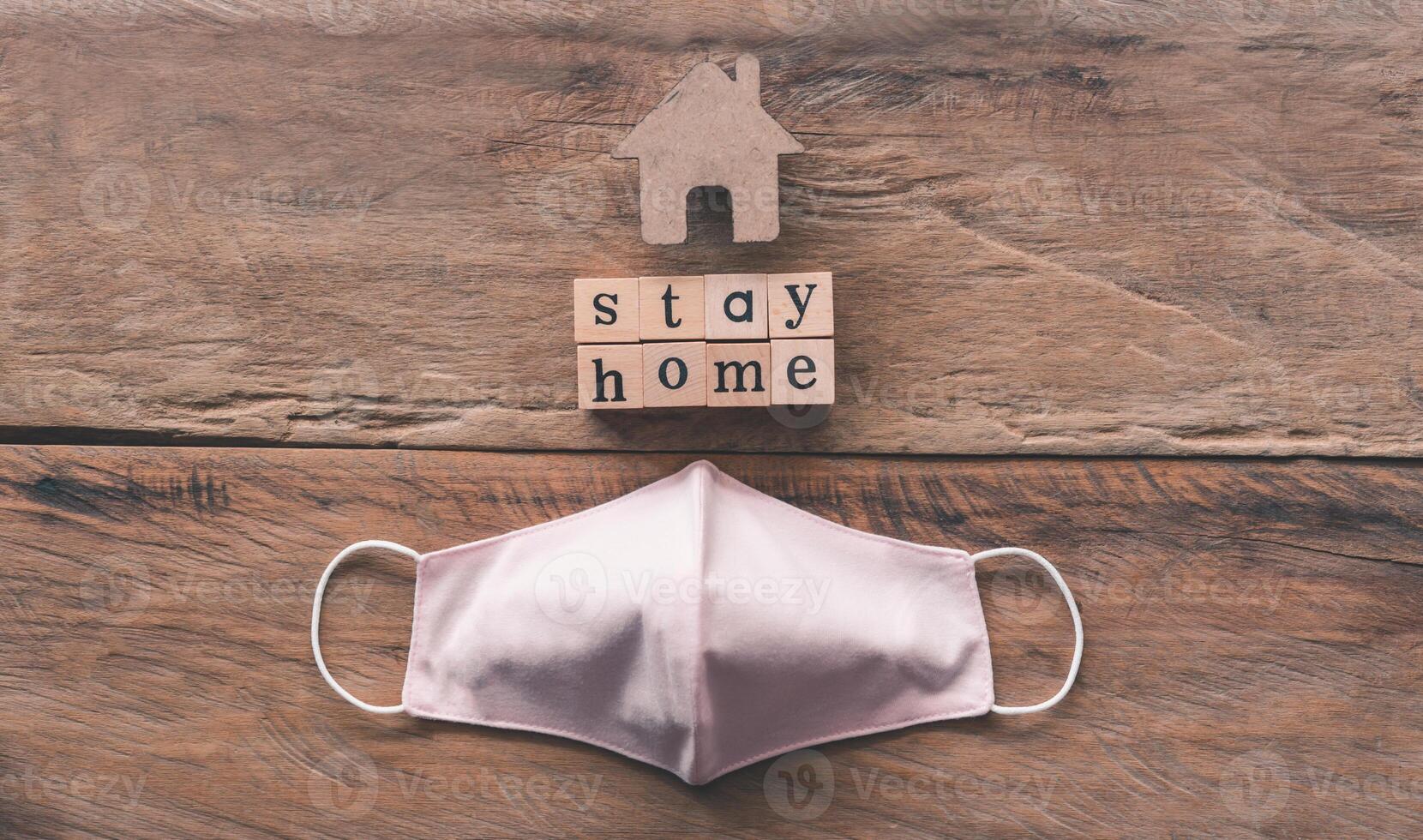 Sanitary napkin mask and the message on the wooden block saying stayhome, the concept of a campaign to prevent the spread of the corona virus photo