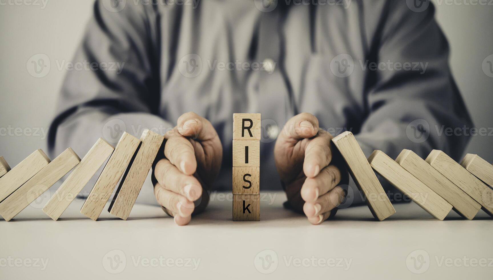 close-up hand The hand of a businessman who is stopping or preventing a falling block.Risk protection concept,Eliminating the risk photo