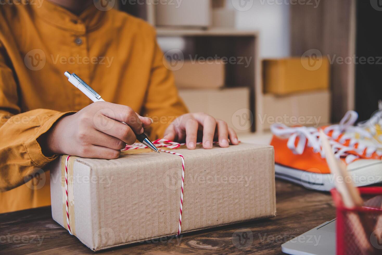 Online small business owner is writing the name, address on the product box to the customer according to the online order-Shopping online concept. photo