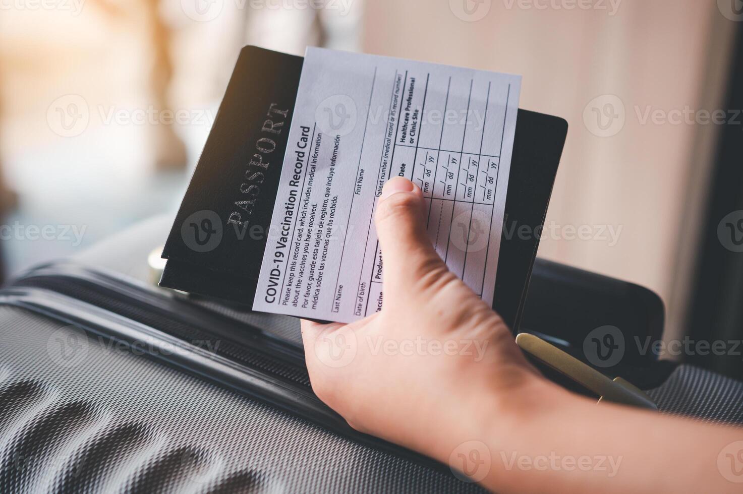 People holding passports and coronavirus vaccination card, map for travel with luggage for the trip. Covid-19 around the world photo