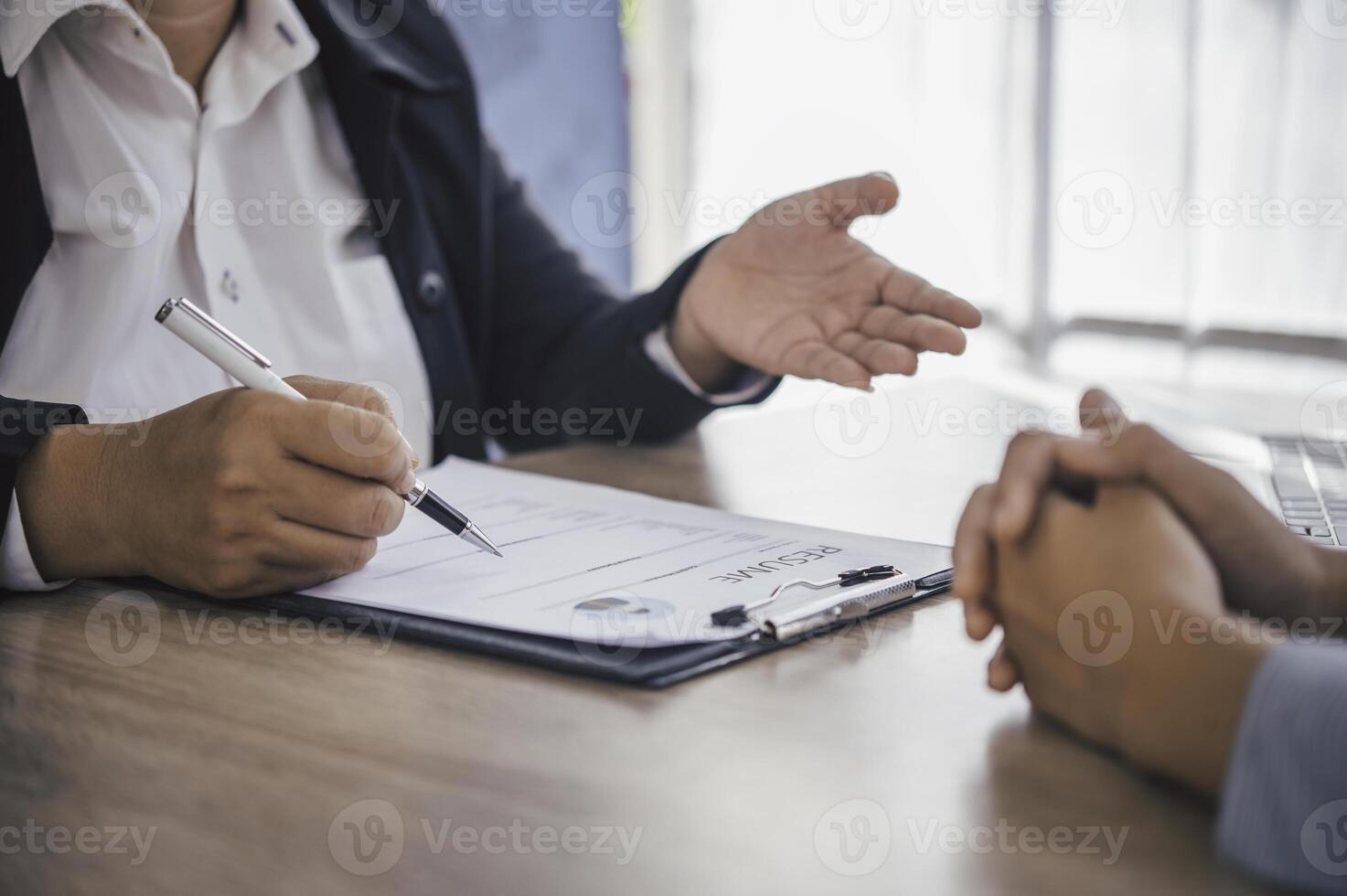 Human resource manager Is explaining the job to the job seeker before filling out a resume on the application form to consider accepting for employment in the company. photo