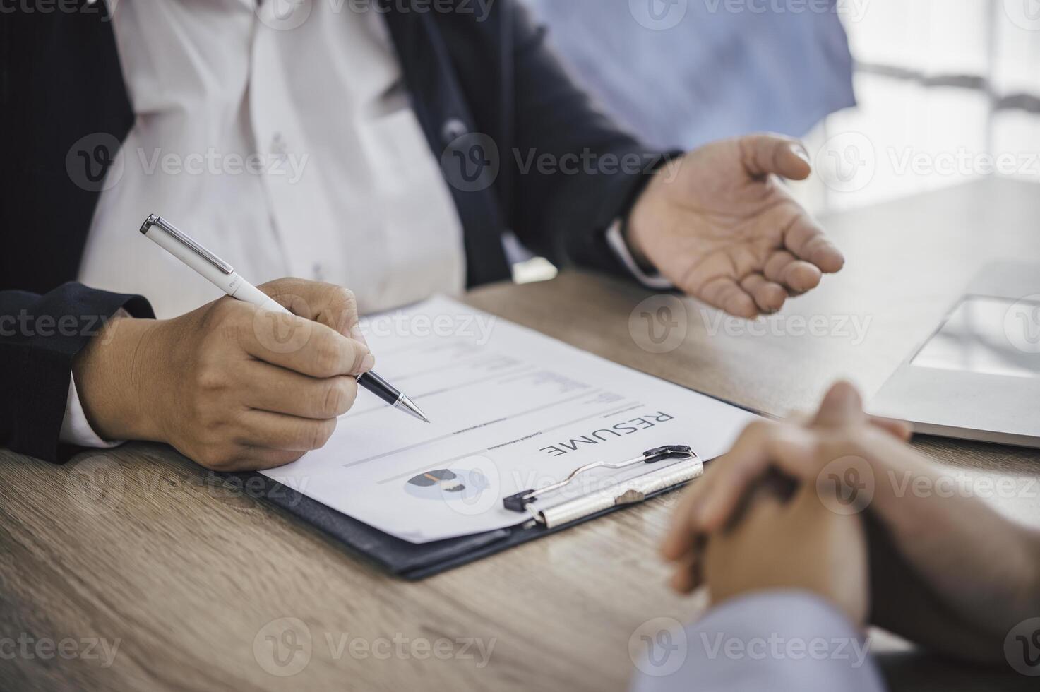 Human resource manager Is explaining the job to the job seeker before filling out a resume on the application form to consider accepting for employment in the company. photo