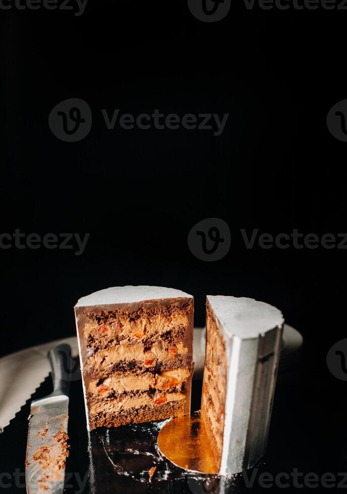 Amazing Cakes. Sliced chocolate wedding cake cake with amazing filling on a black background.Large cake in white chocolate photo