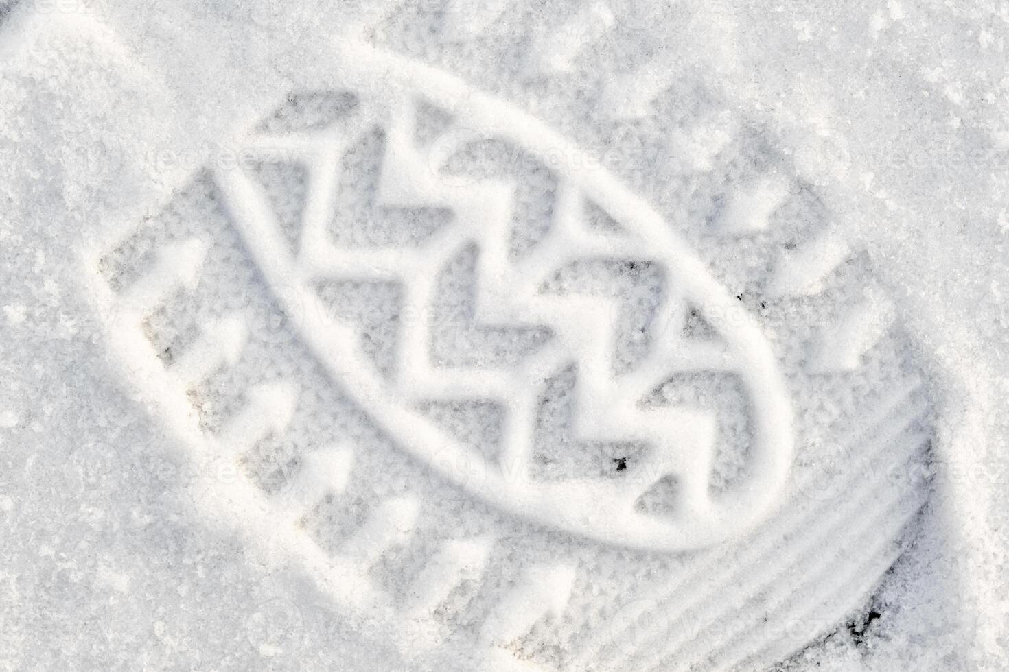 Close-up of a shoe print in the snow, top view of a boot footprint photo