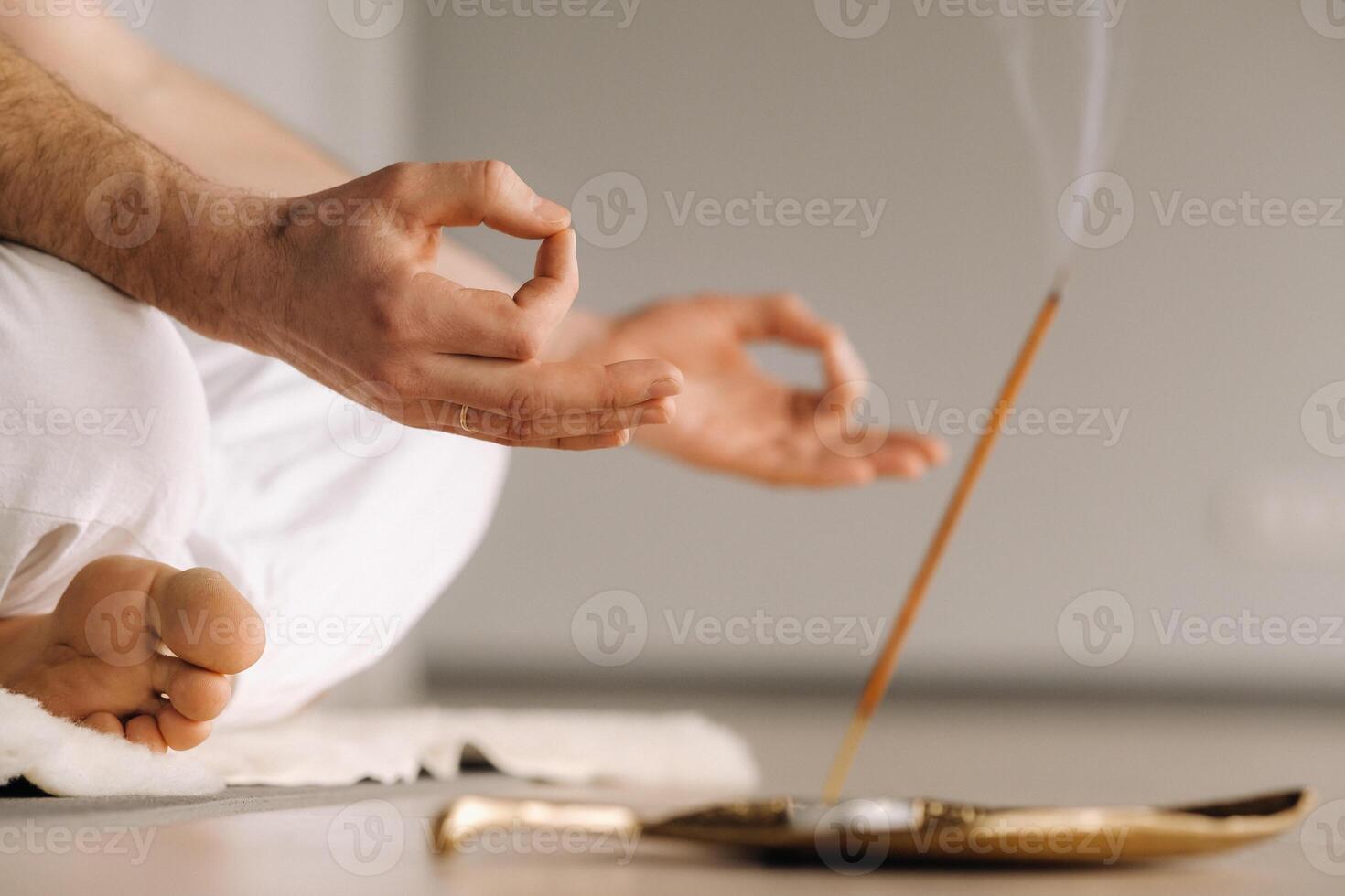 Close-up of a man in white sportswear doing yoga in a fitness room with a balgovon. the concept of a healthy lifestyle photo