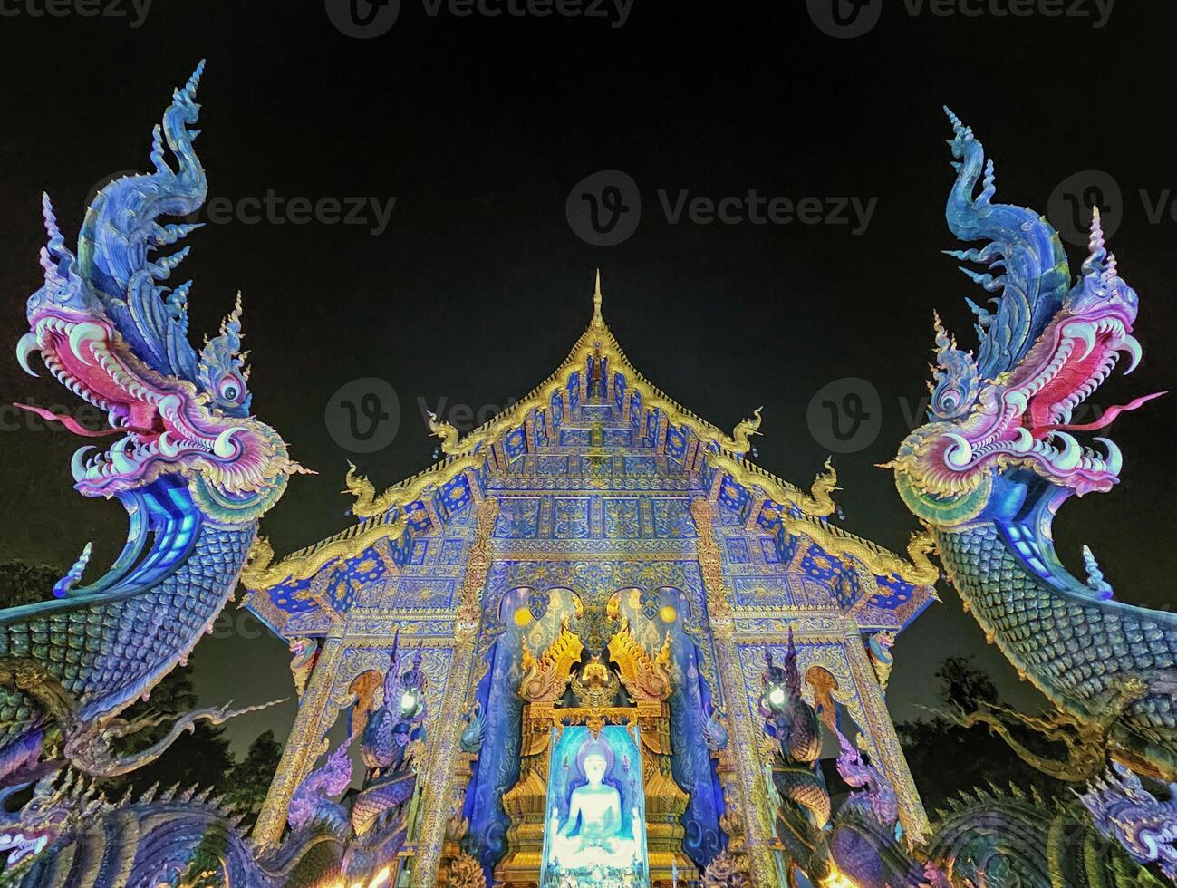 viharn y dragones a wat rong suea diez azul templo por noche, chiang rai, Tailandia foto