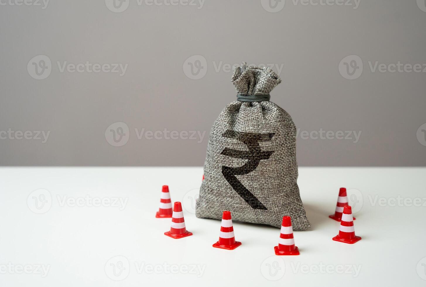 Indian rupee money bag blocked by road cones. Freezing of accounts and sanctions on capital. Suspicious funds with unknown sources. National money reserve. photo