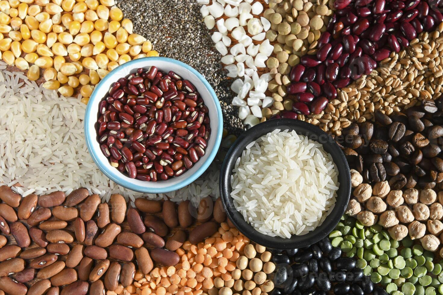 Bowl with raw white rices and beans on various seeds grain photo