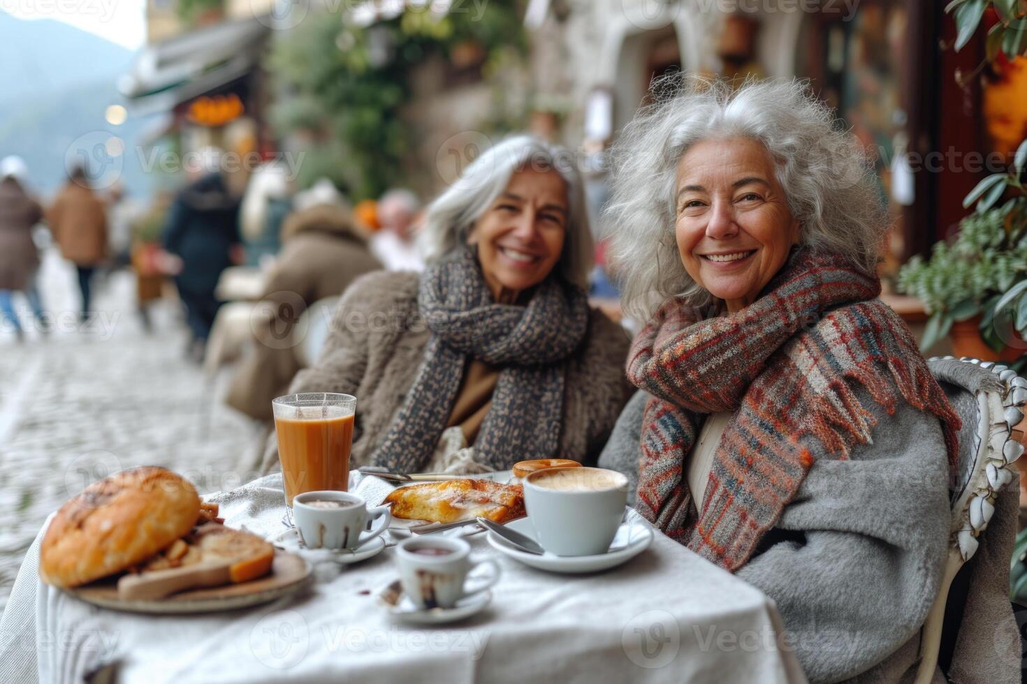 AI generated Two elderly female friends are sitting at an outdoor table with cups of coffee and smiling at the camera photo