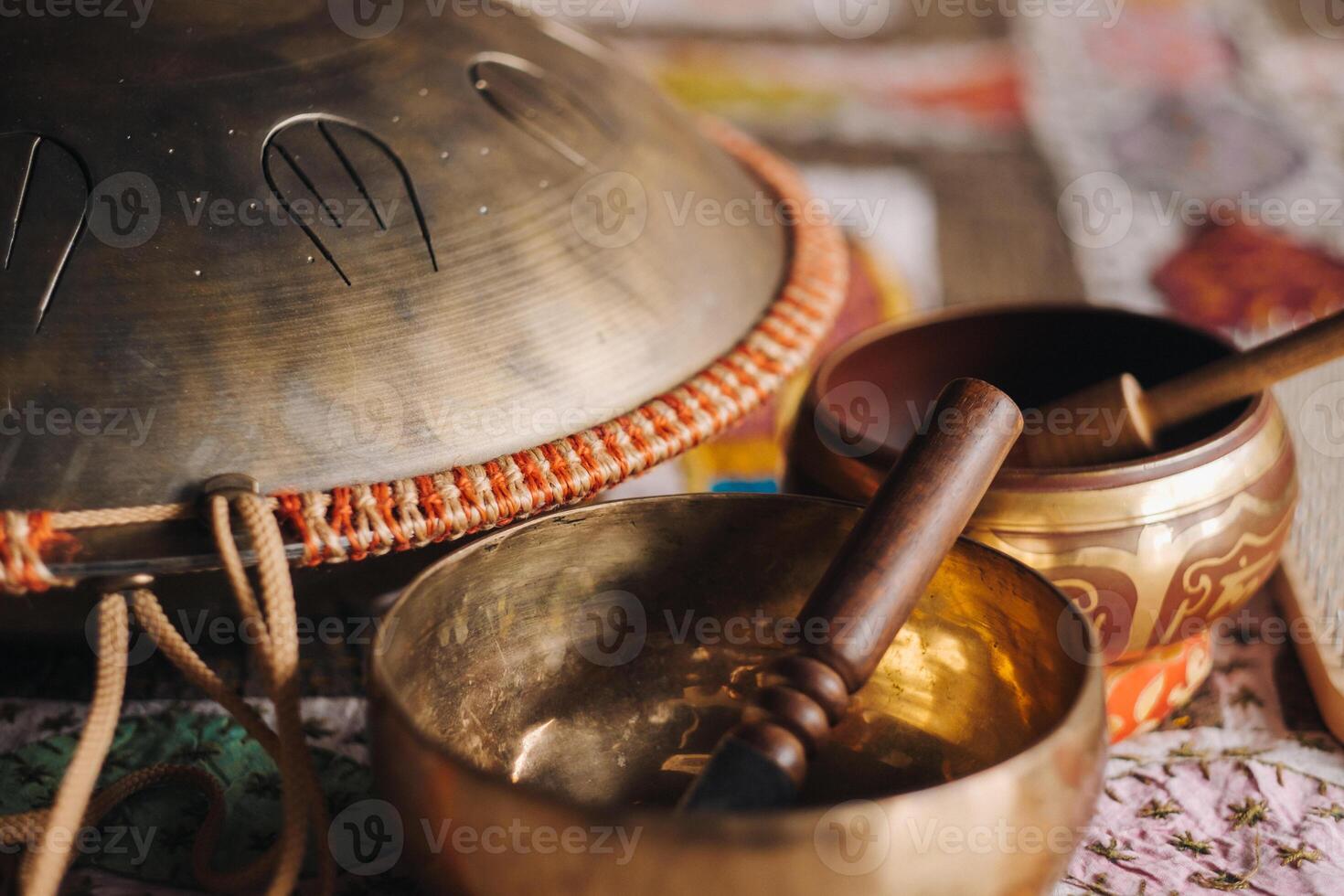 Tongue drum and Tibetan bowls lying on the carpet photo