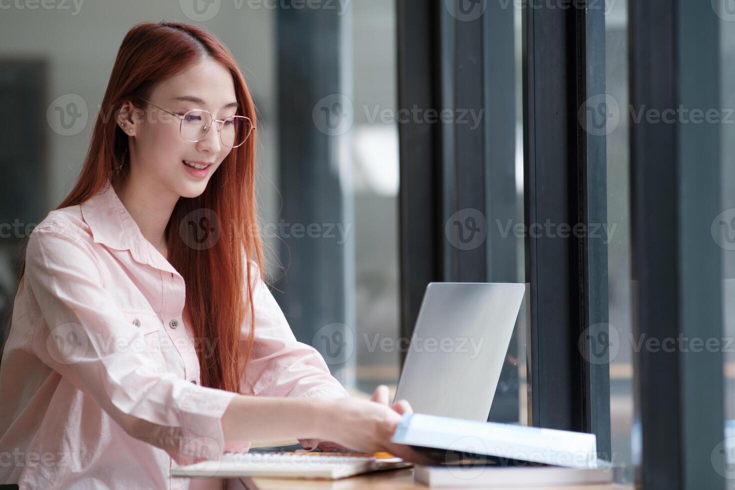 Young collage student using computer and mobile device studying online. photo
