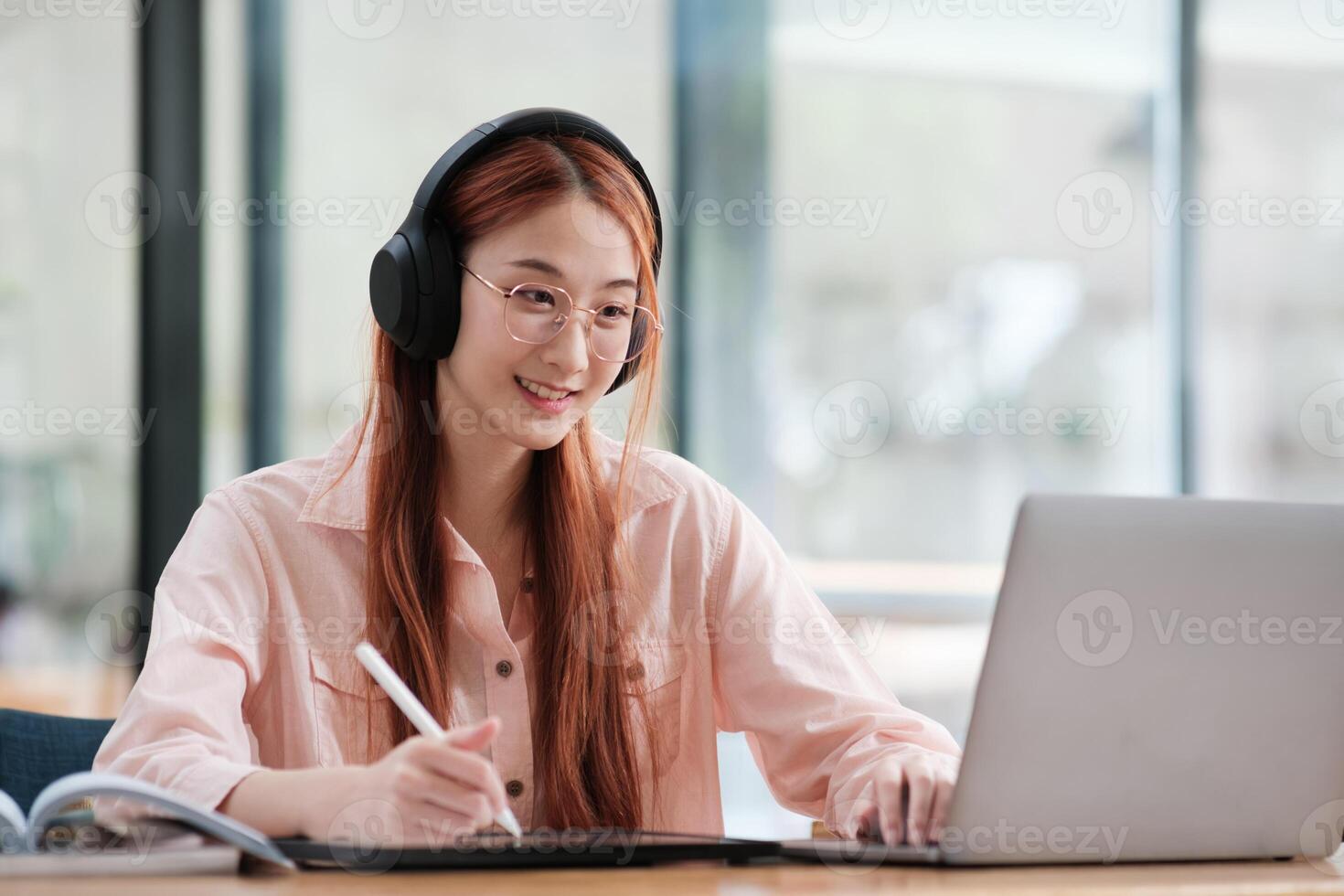 Young collage student using computer and mobile device studying online. photo