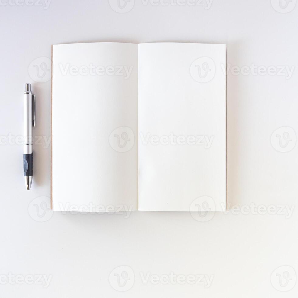 Open white blank on white background with pen. Travel notebook or sketchbook. photo