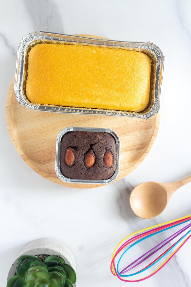 mantequilla pastel y duende en redondo de madera plato en mármol escritorio foto