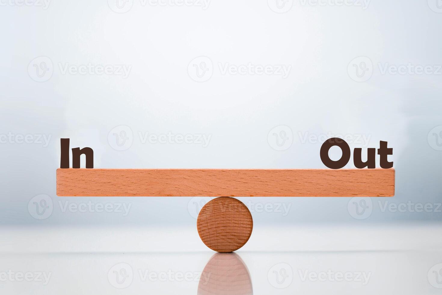 In vs Out word balancing on seesaw choice concept photo
