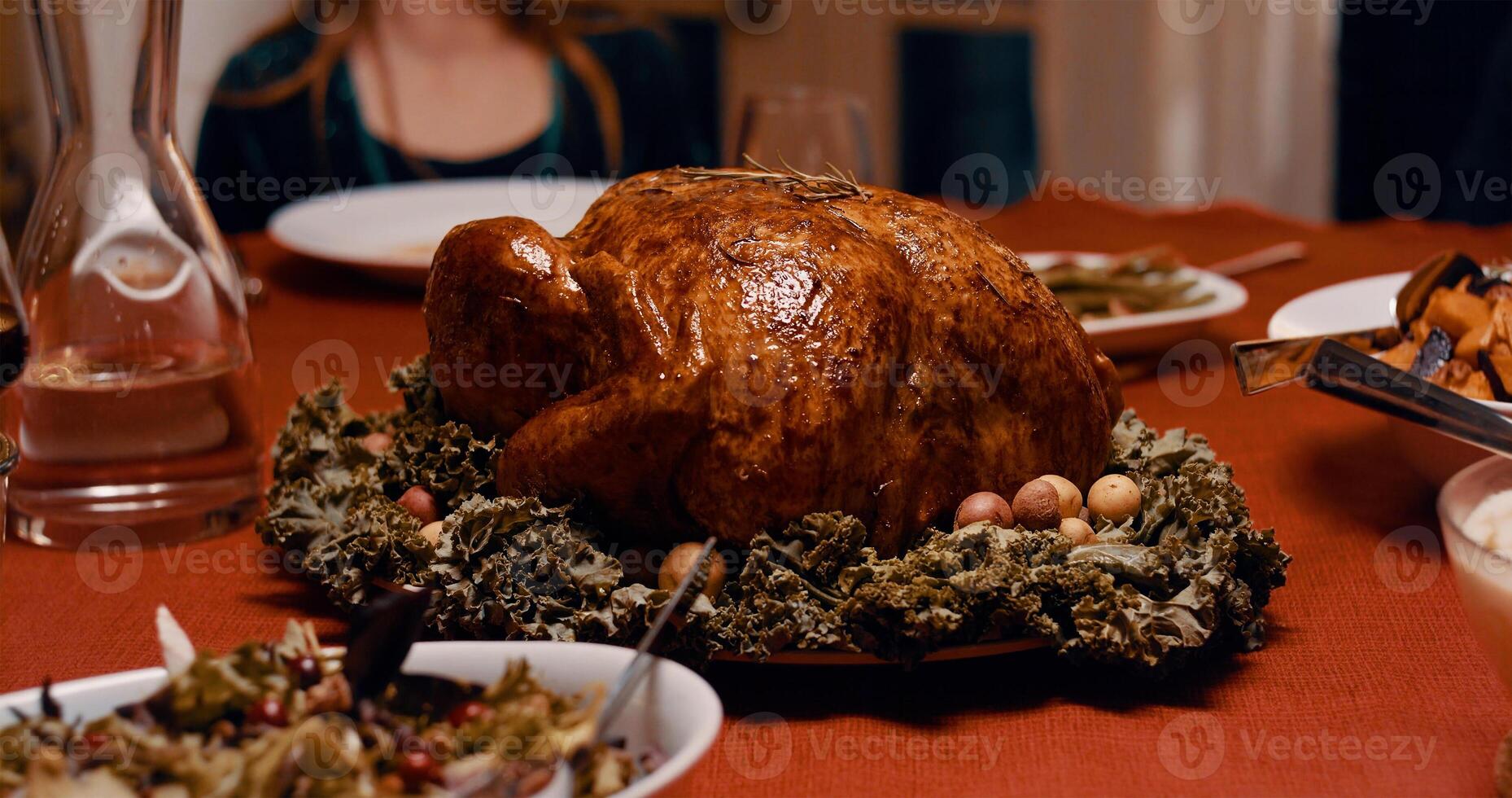 Roasted turkey garnished with cranberries on a rustic style table decoraded with pumpkins, gourds, asparagus, brussel sprouts, baked vegetables, pie, flowers, and candles. photo