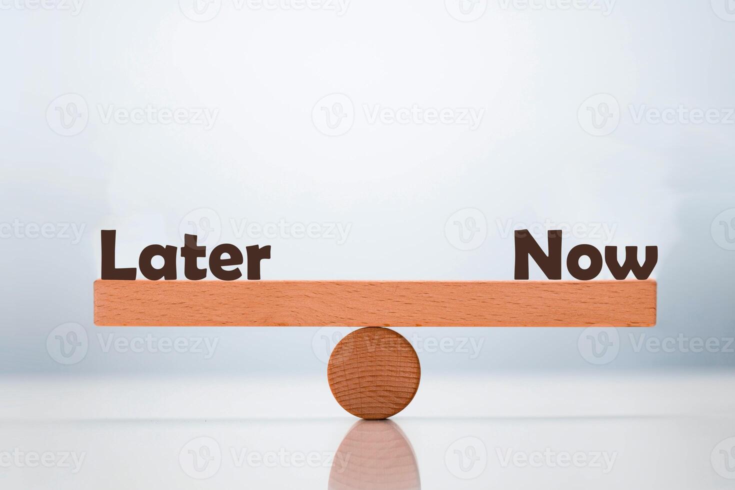 Later vs Now word balancing on seesaw choice concept photo