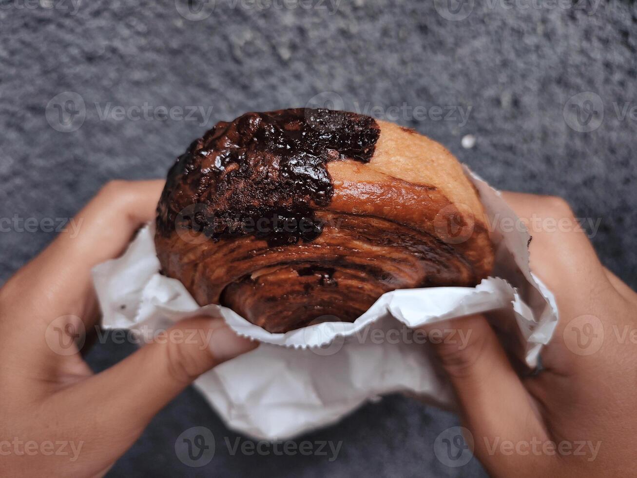 manos participación cromboloni, redondo cuerno, nuevo York rollo, un viral Pastelería combinatorio croissants y bomboloni en hormigón pared antecedentes. foto