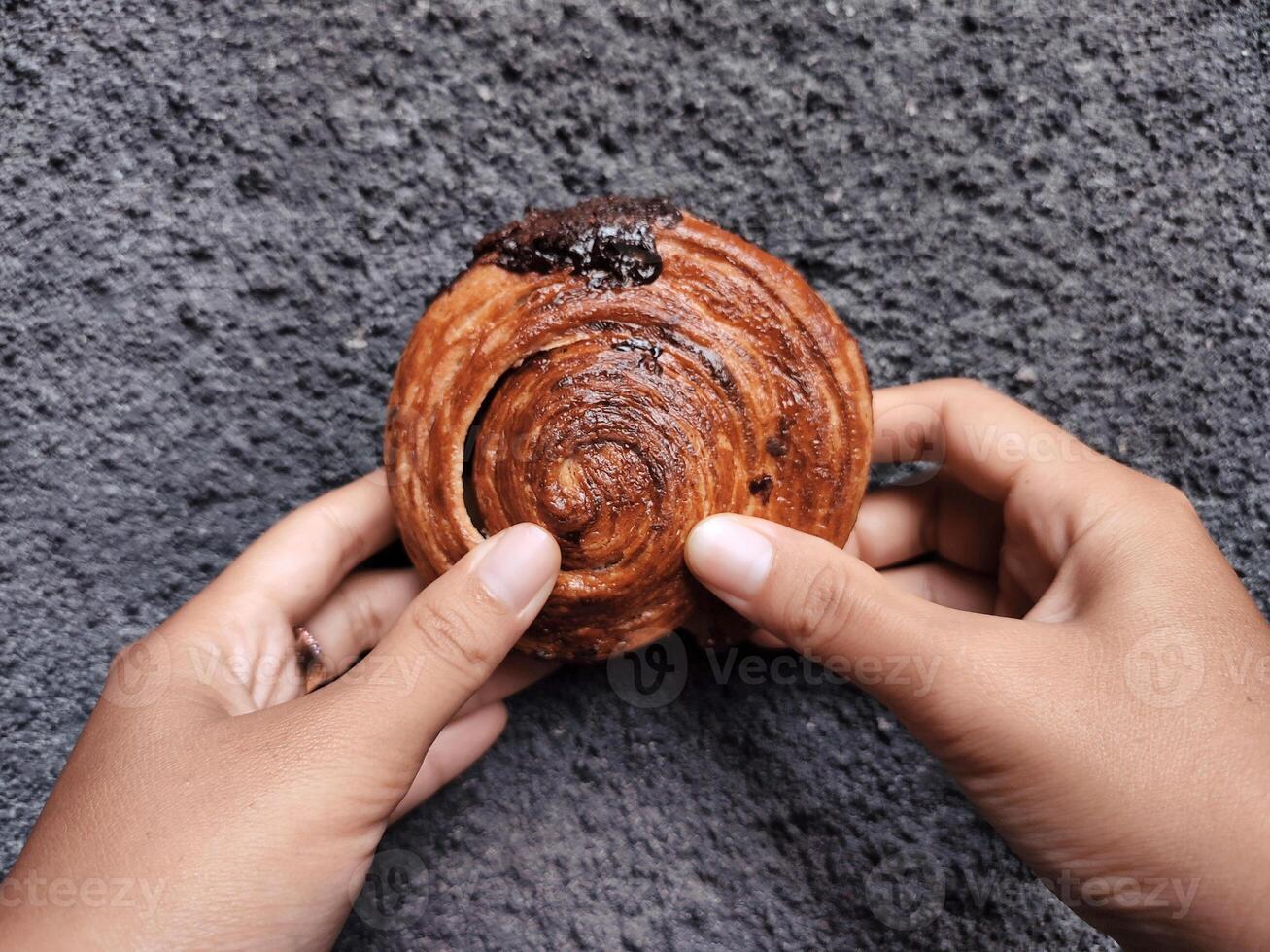 manos participación cromboloni, redondo cuerno, nuevo York rollo, un viral Pastelería combinatorio croissants y bomboloni en hormigón pared antecedentes. foto