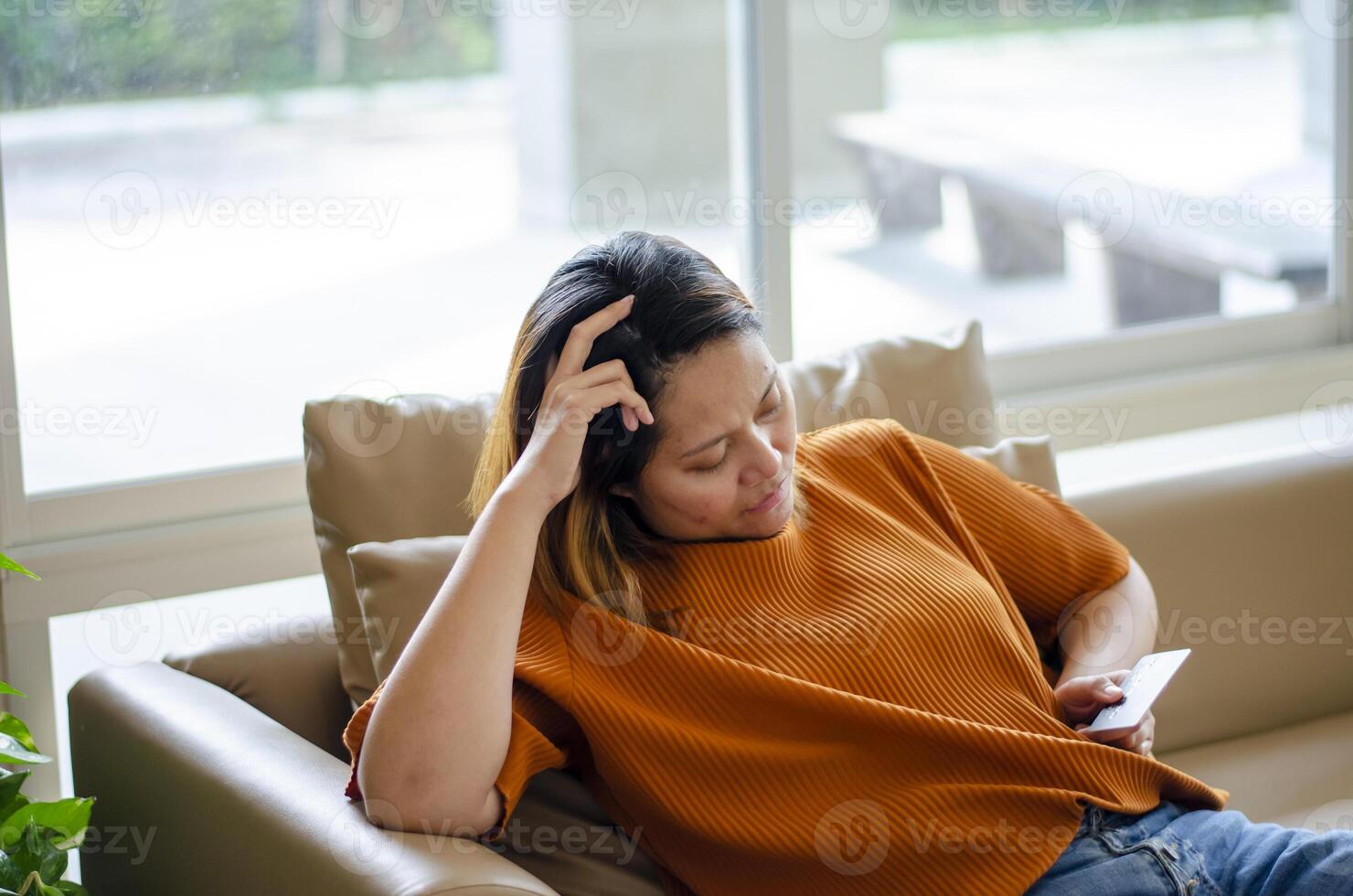 Stressed woman sitting looking at credit card because of running out of money and spending a lot photo