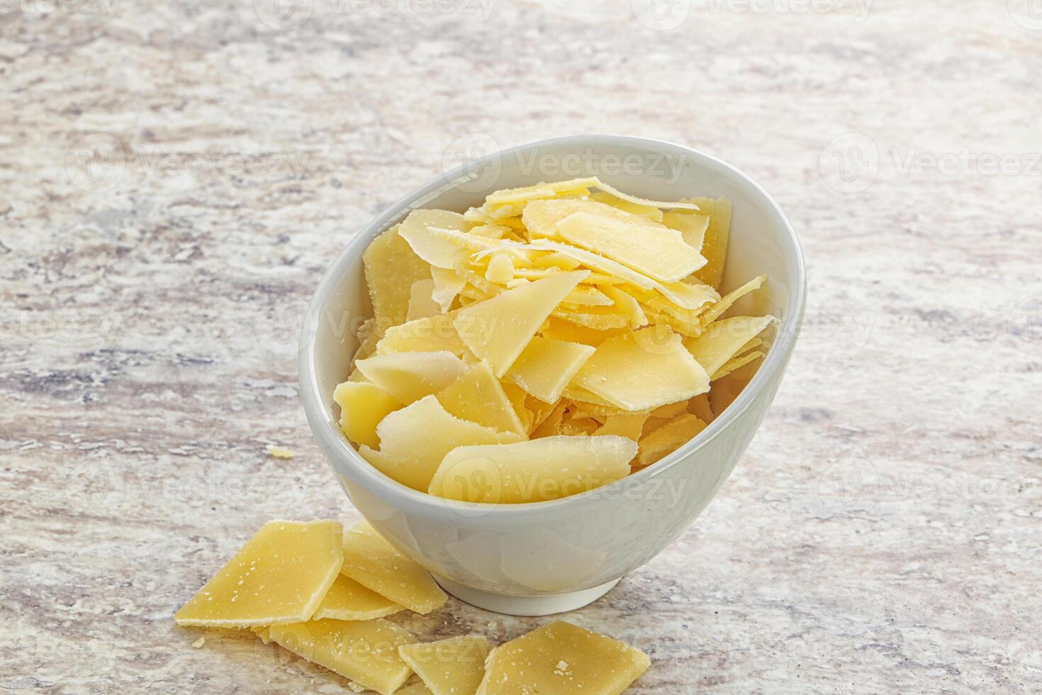 Sliced parmesan cheese heap in the bowl photo