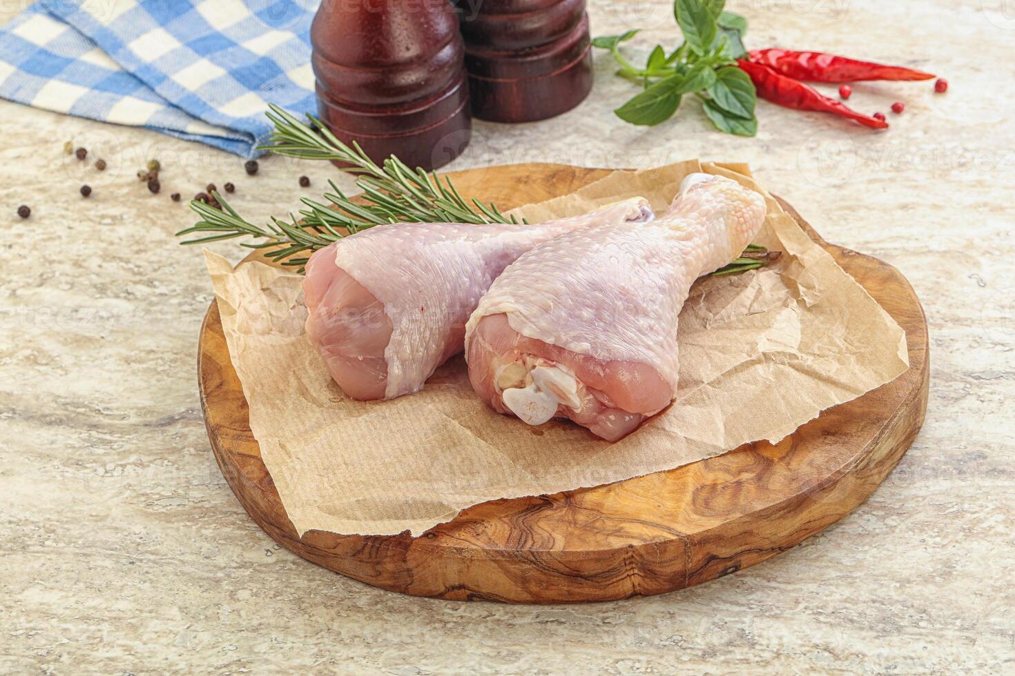 Raw chicken leg over board photo