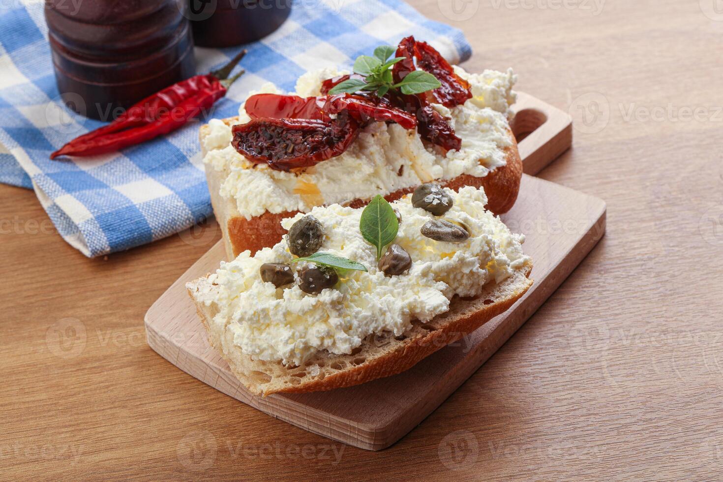 bruschetta with soft cheese capers and tomato photo