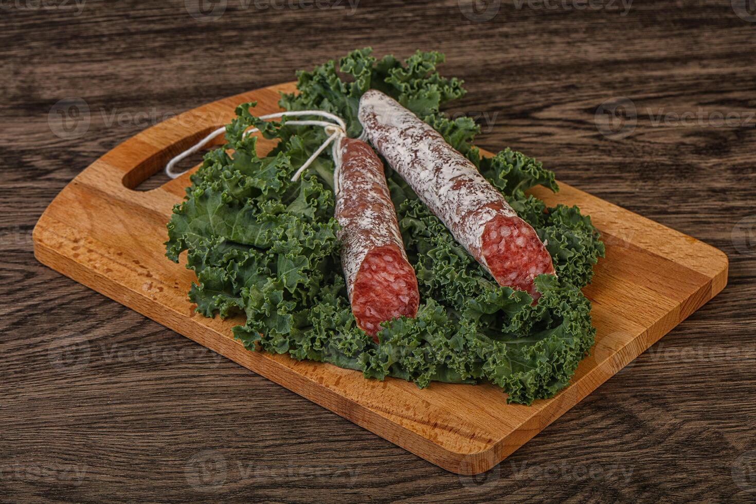 Salchichón de fuet español con hojas de ensalada foto