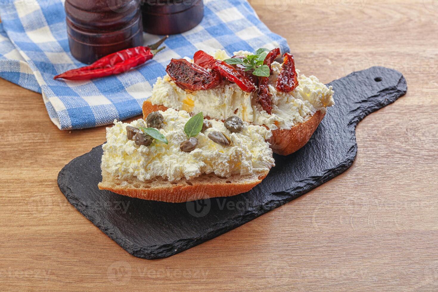 bruschetta with soft cheese capers and tomato photo