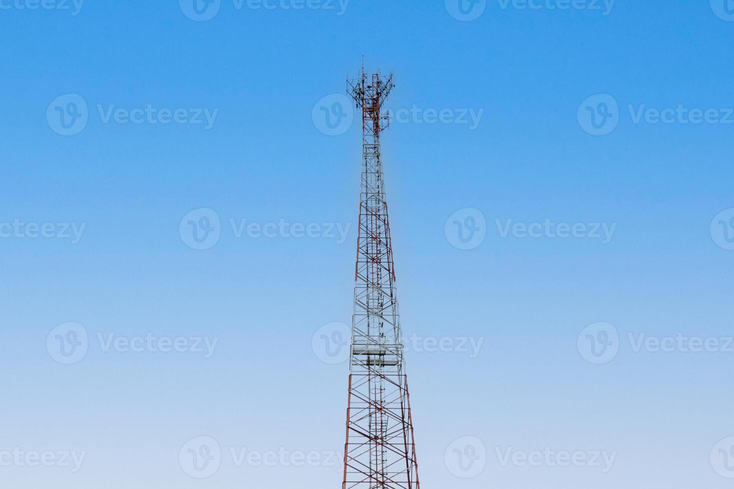 Internet signal tower or mobile phone signal tower isolated on blue sky background texture. Global communication and internet network connection concep photo