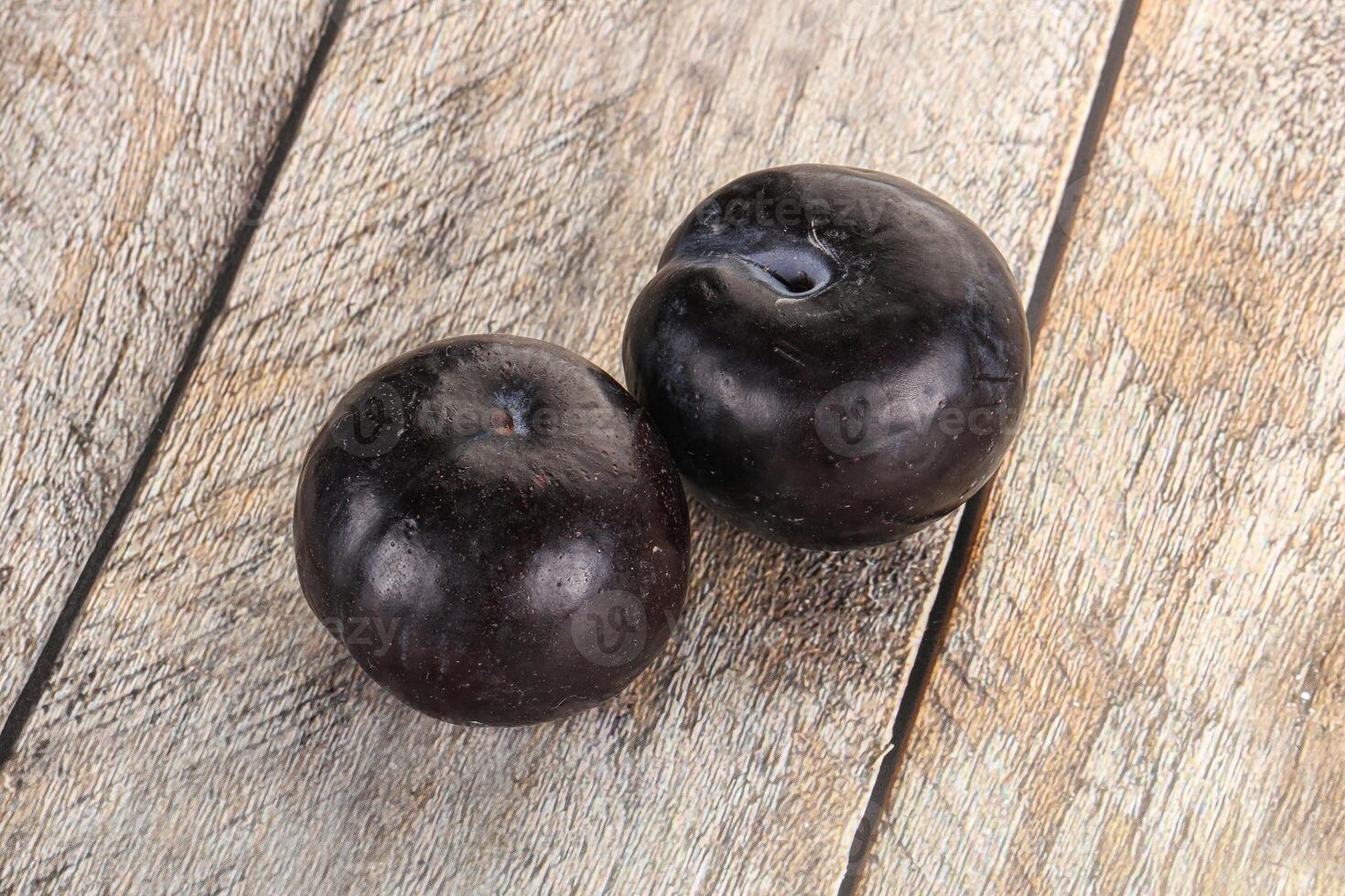 Two ripe sweet black plums photo