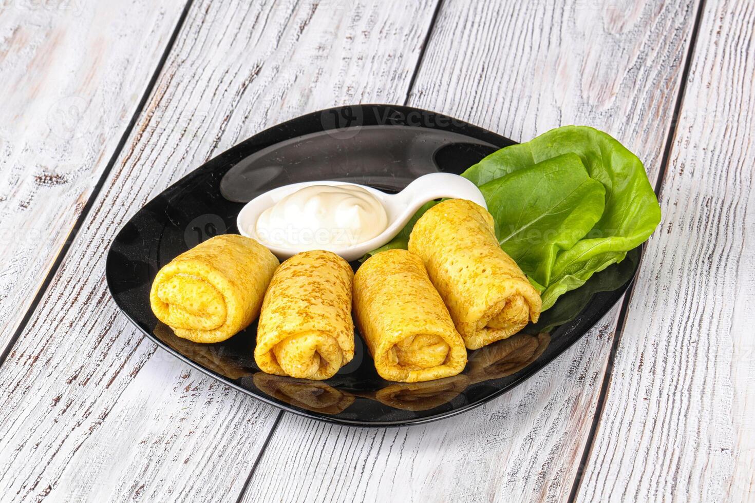 Stuffed pancakes with cream sauce photo