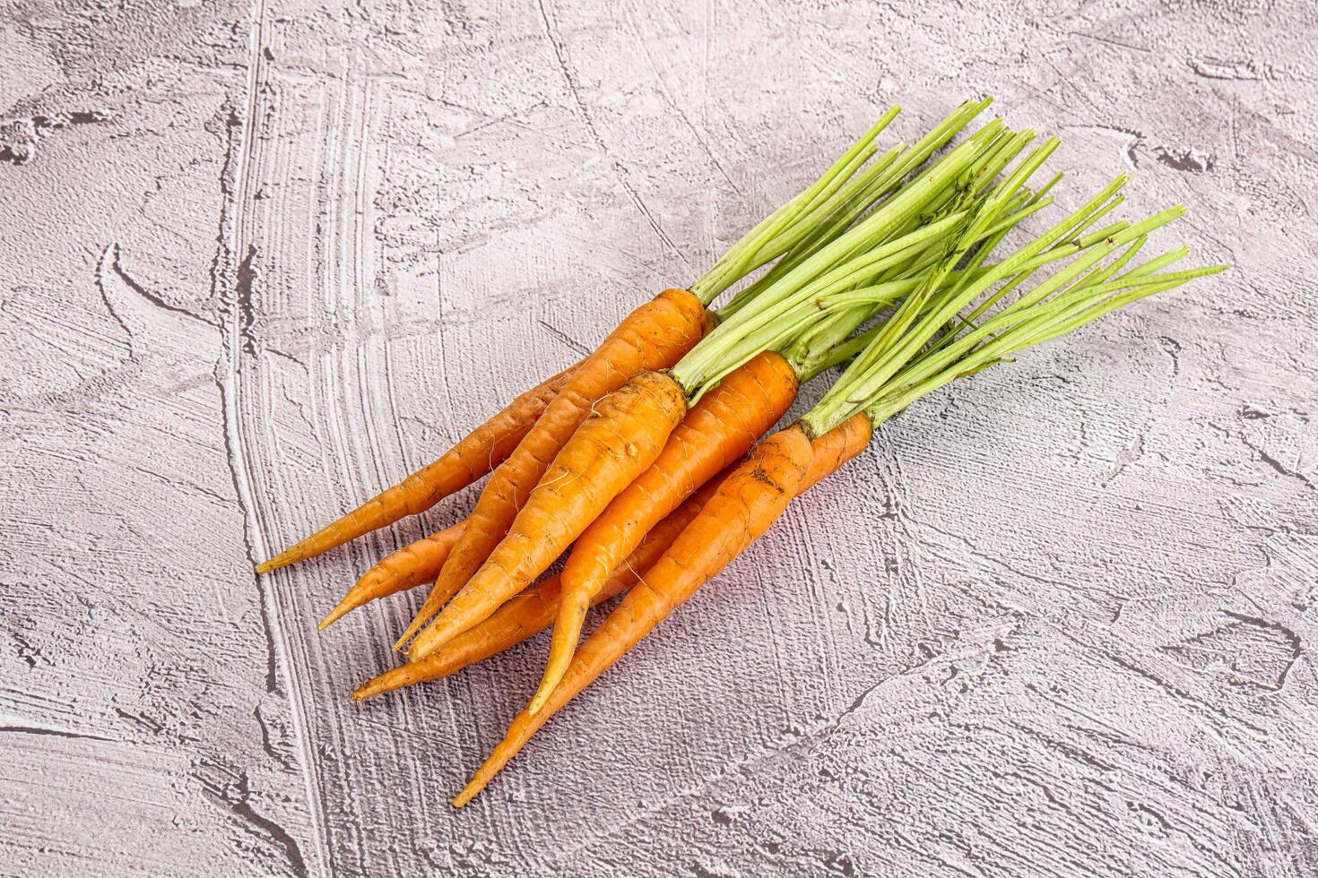 Young raw carrot heap isolated photo